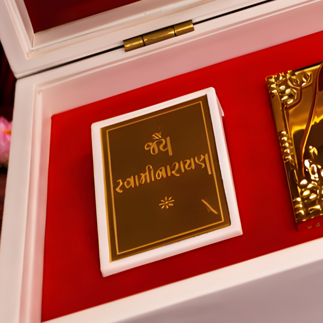 24 Karat Gold Plated Jai Swaminarayan Idol in White Charan Paduka Box with Chandan Fragrance